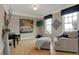 Bright, spacious living room with cozy armchair, large windows, wood floors, and a stylish decor at 2627 Congress St, Carmel, IN 46032