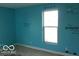 A bedroom featuring custom turquoise walls, a window, and painted decals at 2811 S Elm St, Muncie, IN 47302