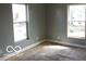 Bedroom featuring natural light from two windows, gray walls, and wood floors at 2811 S Elm St, Muncie, IN 47302