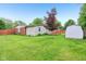 Landscaped backyard with green lawn, a small tree, and a wooden deck with railings at 2910 S Sheridan Ave, Indianapolis, IN 46203