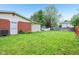 Green backyard featuring well-maintained lawn, brick exterior, and a storage shed at 2910 S Sheridan Ave, Indianapolis, IN 46203
