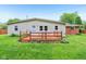 View of the home's back exterior, featuring a wooden deck and lush green lawn at 2910 S Sheridan Ave, Indianapolis, IN 46203