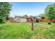 A spacious backyard with a wooden deck, lush lawn, and mature trees at 2910 S Sheridan Ave, Indianapolis, IN 46203