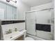 Traditional bathroom with black and white tile, frosted glass shower door, and vanity at 2910 S Sheridan Ave, Indianapolis, IN 46203