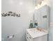 This bathroom features a large mirror over a vanity with a sink and a decorative metal wall hanging at 2910 S Sheridan Ave, Indianapolis, IN 46203