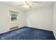 This bedroom is carpeted and has a window with curtains, a ceiling fan, and light-colored walls at 2910 S Sheridan Ave, Indianapolis, IN 46203
