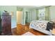 Bedroom featuring two windows, wood flooring, and an accent wall at 2910 S Sheridan Ave, Indianapolis, IN 46203