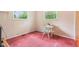 Cozy bedroom features pink carpet, white wicker chair and table, and natural light from two windows at 2910 S Sheridan Ave, Indianapolis, IN 46203