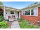 Inviting covered front porch featuring red brick, decorative plants, and an intimate seating area at 2910 S Sheridan Ave, Indianapolis, IN 46203