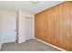 Bedroom featuring neutral colored carpet, light pink paint and dark wood paneling at 3015 E Sumner Ave, Indianapolis, IN 46237