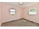 Bright bedroom with two windows illuminating the neutral colored carpet and light pink paint at 3015 E Sumner Ave, Indianapolis, IN 46237