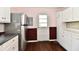 Kitchen area featuring stainless steel refrigerator, white cabinets, and tiled backsplash at 3015 E Sumner Ave, Indianapolis, IN 46237