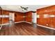 Open living room showcasing wood-look flooring, dark wood paneling and seamless flow to other rooms at 3015 E Sumner Ave, Indianapolis, IN 46237