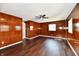 Large living room with dark wood paneling, wood-look flooring and a ceiling fan for comfort at 3015 E Sumner Ave, Indianapolis, IN 46237