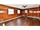 Bright living room with wood-look floors, dark wood paneling and a view into an adjacent room at 3015 E Sumner Ave, Indianapolis, IN 46237