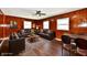 Spacious living room with wood paneling, ceiling fan, and dark laminate flooring at 3015 E Sumner Ave, Indianapolis, IN 46237