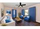 Comfortable living room with blue curtains, plush seating, and wood floors at 3015 E Sumner Ave, Indianapolis, IN 46237