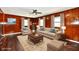 Comfortable living room with wood paneling, neutral-toned furniture, and a ceiling fan at 3015 E Sumner Ave, Indianapolis, IN 46237