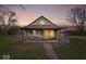 Charming home with a covered porch, complemented by lovely landscaping and a brick pathway at 3070 N Layman Ave, Indianapolis, IN 46218