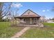 Charming home with a covered porch, complemented by lovely landscaping and a brick pathway at 3070 N Layman Ave, Indianapolis, IN 46218