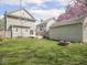 Back yard with green grass and a firepit is bordered by wood fencing at 317 E 37Th St, Indianapolis, IN 46205