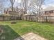 Large backyard featuring a fire pit, green grass, and surrounded by a wooden fence at 317 E 37Th St, Indianapolis, IN 46205