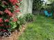 Lush landscaping featuring bright red honeysuckle and a charming blue chair at 317 E 37Th St, Indianapolis, IN 46205