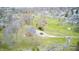 Aerial view of the brick ranch home surrounded by mature trees and grassy creek area at 345 E Main St, Jamestown, IN 46147