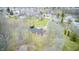 An aerial view showing the brick ranch home surrounded by trees, creek, and spacious lawn at 345 E Main St, Jamestown, IN 46147