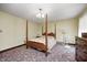 Bedroom with four-poster bed, floral patterned carpet, chandelier, dresser and fan at 345 E Main St, Jamestown, IN 46147