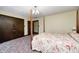 Bedroom with dark wooden closet doors and bed with floral bedding and chandelier at 345 E Main St, Jamestown, IN 46147