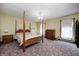 Bedroom with four-poster bed, floral patterned carpet, chandelier, and dresser at 345 E Main St, Jamestown, IN 46147