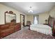 Bedroom featuring a wood dresser, a small chair, and a bed frame with neutral bedding at 345 E Main St, Jamestown, IN 46147