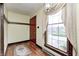 Bright entryway featuring a hardwood floor, a red door, and a sunlit window with elegant drapery at 345 E Main St, Jamestown, IN 46147