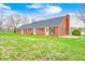 Charming brick ranch home featuring a chimney and a well-maintained lawn with brick patio area at 345 E Main St, Jamestown, IN 46147