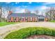Attractive single-story red brick home with a well manicured circular driveway and attached garage at 345 E Main St, Jamestown, IN 46147