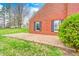 Brick patio with two windows and fresh green bush next to the beautiful lawn at 345 E Main St, Jamestown, IN 46147