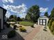 Well-manicured backyard featuring a storage shed, lush landscaping, and a meticulously maintained lawn at 401 Paddlebrook Dr, Danville, IN 46122