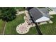 An aerial shot of a beautifully landscaped backyard with patio seating, fire pit, storage shed and lush green lawn at 401 Paddlebrook Dr, Danville, IN 46122