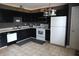 A modern kitchen features black cabinets, white appliances, and updated fixtures at 401 Paddlebrook Dr, Danville, IN 46122