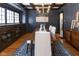 Elegant dining room with dark blue walls, hardwood floors, and modern chandelier at 4030 N Illinois St, Indianapolis, IN 46208