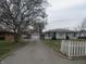 Street view showcasing a light-colored single-story home with a detached garage and a long driveway at 406 W Jackson St, Alexandria, IN 46001