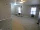 Cozy living room with plush carpeting, neutral walls, bright windows, and a table with stools at 406 W Jackson St, Alexandria, IN 46001
