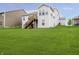 Expansive backyard featuring a well-maintained lawn and a wooden deck with stairs at 4196 Parliament Way, Avon, IN 46123