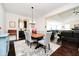 Bright dining room featuring a modern light fixture, dark wood floors, and a gray and white rug at 4196 Parliament Way, Avon, IN 46123