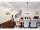 Open dining room with an elegant chandelier, and gray upholstered chairs at a light wood table at 4196 Parliament Way, Avon, IN 46123