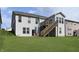 Back exterior of a two-story home with a wooden deck, a staircase, and a well-maintained lawn at 4196 Parliament Way, Avon, IN 46123
