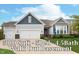 Charming two-story home with three-car garage, gray siding and stone accents on a well-manicured lawn at 4196 Parliament Way, Avon, IN 46123