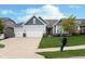 Charming home showcasing a three-car garage, green lawn, dark red front door, and tidy landscaping at 4196 Parliament Way, Avon, IN 46123