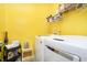 Well-equipped laundry room with modern washer and dryer, storage shelves, and bright yellow walls at 4196 Parliament Way, Avon, IN 46123